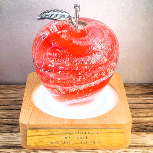red swirl ashes in glass apple on illuminated L.E.D light stand with engraved plaque